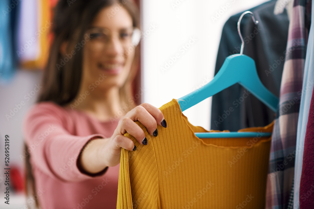 Woman choosing clothes on a rack Woman choosing clothes on a rack