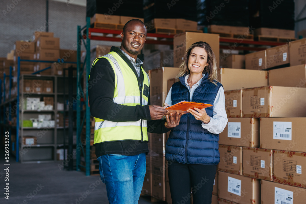 Logistics employees holding a waybill in a warehouse Logistics employees holding a waybill in a warehouse