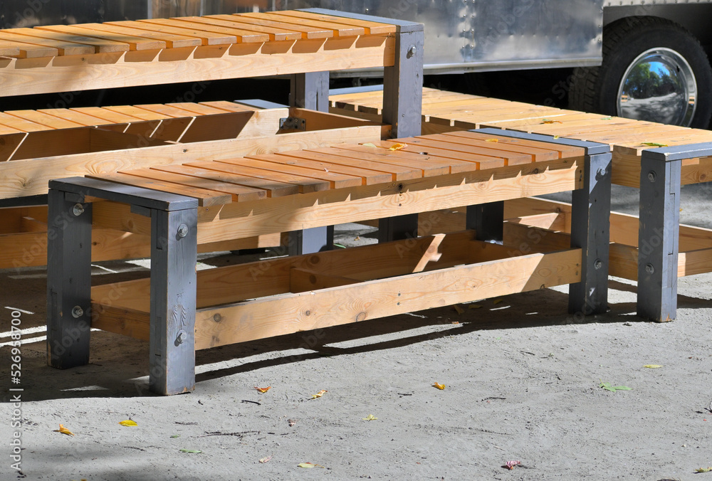 Wooden park benches unloaded from a van on a summer day Wooden park benches unloaded from a van on a summer day