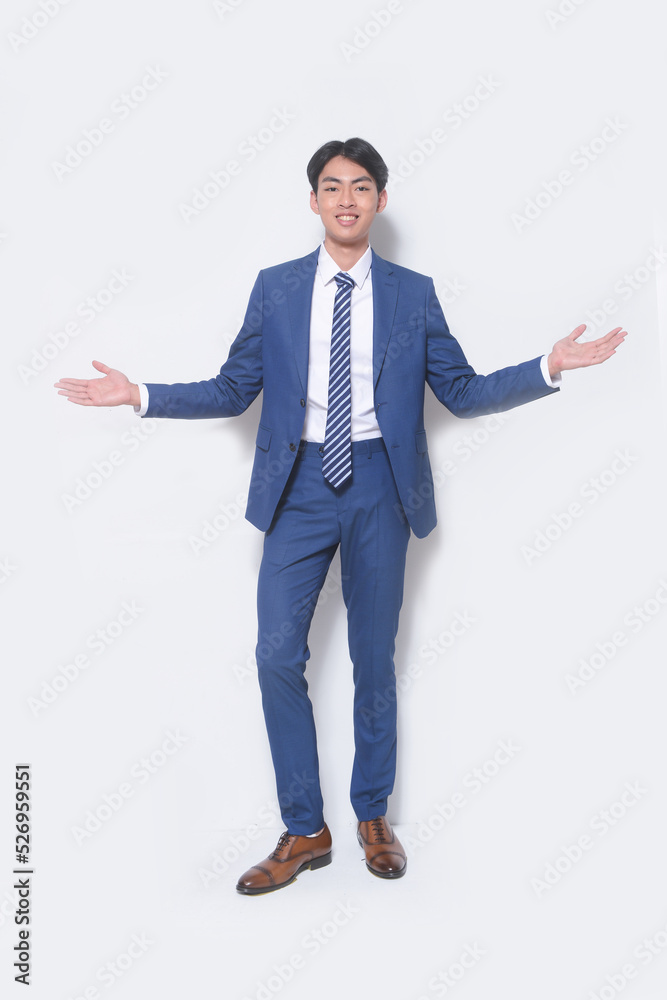 Full body young businessman wearing suit, blue shirt with tie open hands standing in studio Full body young businessman wearing suit, blue shirt with tie open hands standing in studio