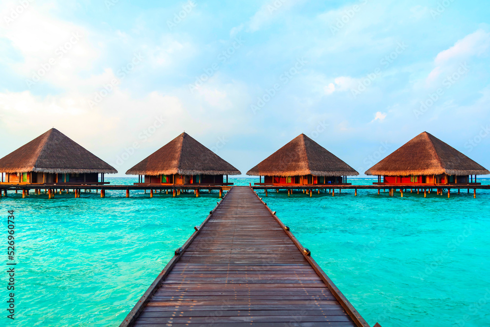 view of the water villas at sunrise in the Maldives, the concept of luxury travel