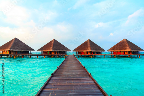 Fototapeta Naklejka Na Ścianę i Meble -  view of the water villas at sunrise in the Maldives, the concept of luxury travel