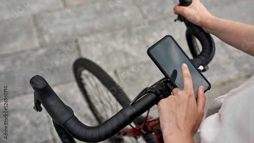 Cropped girl use smartphone on bicycle for routing