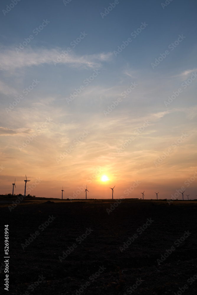 Wind turbines at the sunset in the wind farm in Zaragoza, Spain. Alternative energy sources.