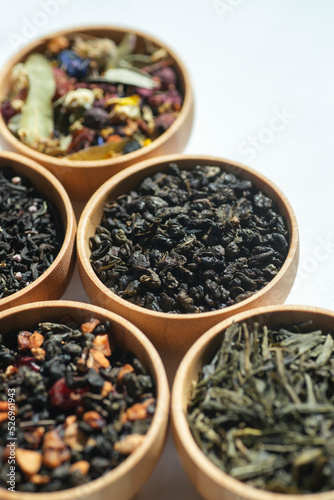Different types of green, black and herbal tea in a wooden bowl. Variety of dry leaves and flowers. Organic high-quality ingredients for a drink