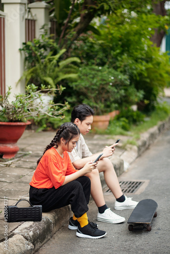 Teenagers Sitting on Pavement