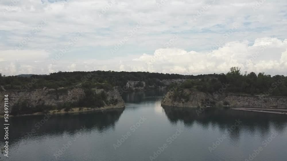A wide, beautiful aerial drone shot of lake zakrzowek in Krakow Poland with green trees and deep blue water A wide, beautiful aerial drone shot of lake zakrzowek in Krakow Poland with green trees and deep blue water