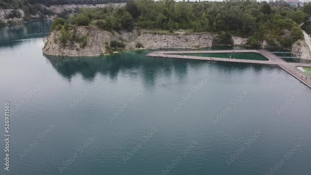 A wide, beautiful aerial drone shot of lake zakrzowek in Krakow Poland with forest right next to it helix shot A wide, beautiful aerial drone shot of lake zakrzowek in Krakow Poland with forest right next to it helix shot