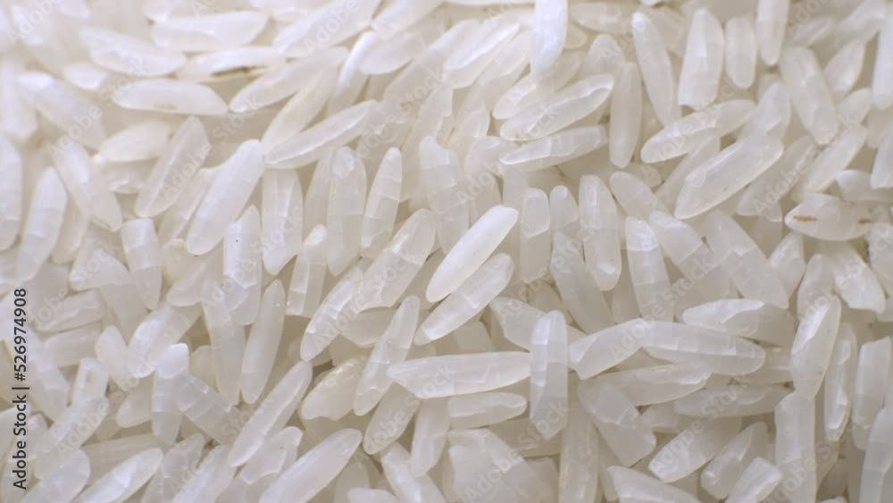 White long polished rice close-up in macro mode rotates in a circle. Selective focus White long polished rice close-up in macro mode rotates in a circle. Selective focus