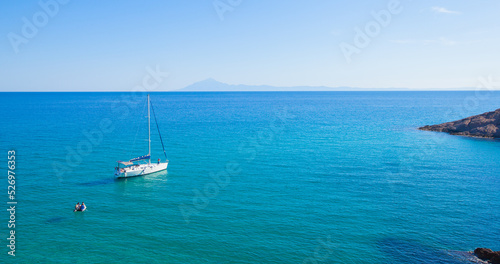 Beautiful seascape with sailing boat on a summer day at bay on the crystal turquoise color sea. Yachting summer travel holiday. Island Thassos, Greece. 