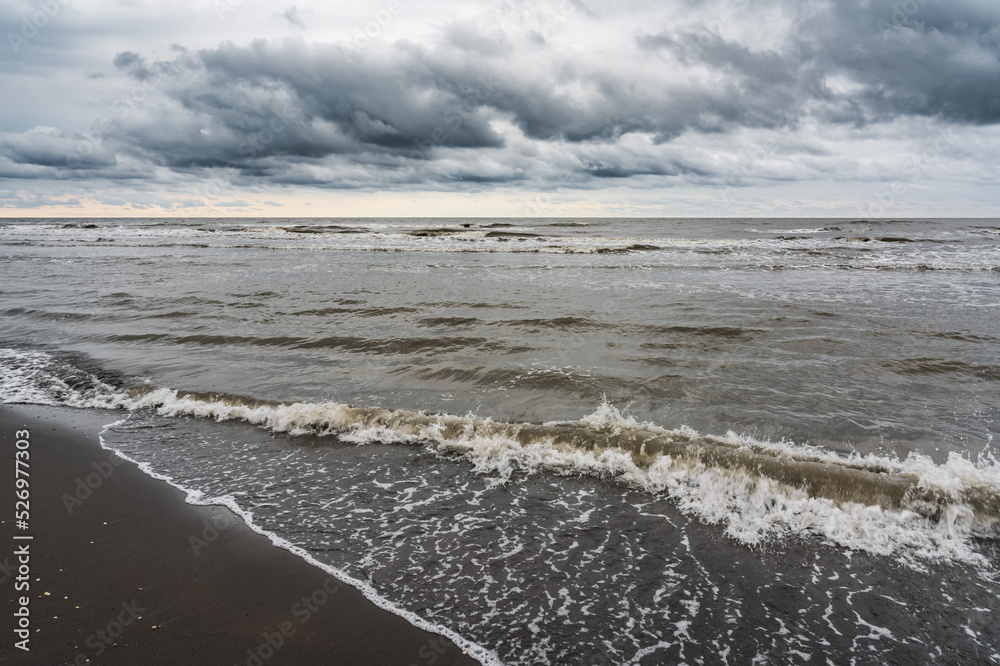Waves on the sea beach on a cloudy rainy day