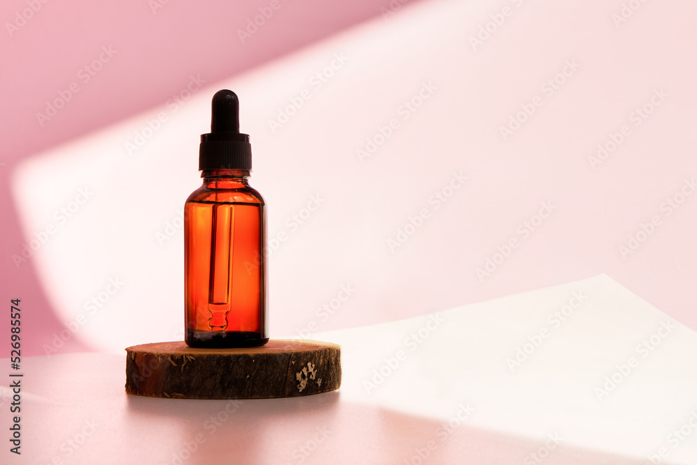 Banner of cosmetic amber glass dropper bottle on wooden podium with oil, serum or fruit peeling in the sunlight. Beauty product presentation, natural pink background. Front view. Mockup concept Banner of cosmetic amber glass dropper bottle on wooden podium with oil, serum or fruit peeling in the sunlight. Beauty product presentation, natural pink background. Front view. Mockup concept