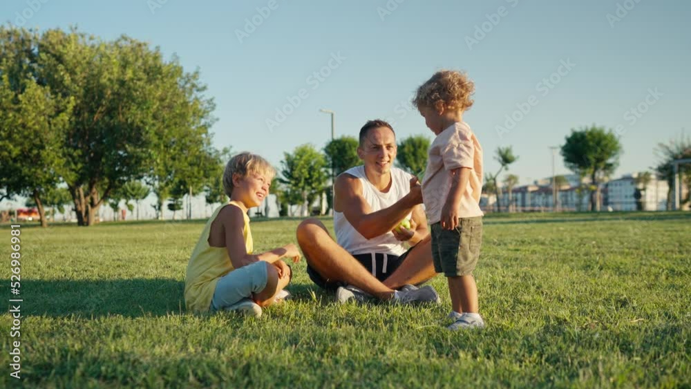 Happy father juggling with green apples in the park with his kids. High quality 4k footage Happy father juggling with green apples in the park with his kids. High quality 4k footage