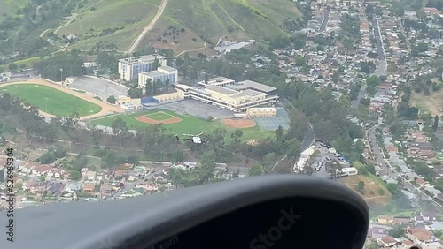 Cockpit of helicopter flying over city photo