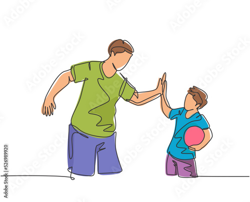 Single line drawing of young happy father and son playing football together on outdoor field and give high five gesture. Parenting concept continuous line draw design vector graphic illustration