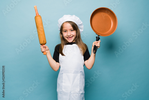 Excited kid cooking delicious food as a chef photo