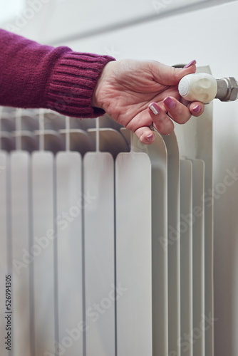 Woman heating on a chilly winter day, energy and gas crisis, cold room, heating problems.