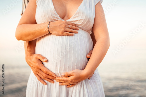 Pregnant woman with her partner holding her belly