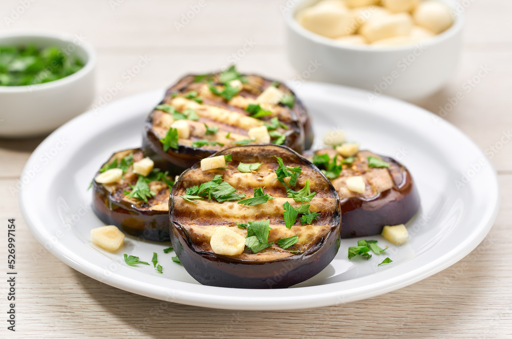 Salad with grilled eggplant, parsley and garlic on a white plate,selective focus. Salad with grilled eggplant, parsley and garlic on a white plate,selective focus.