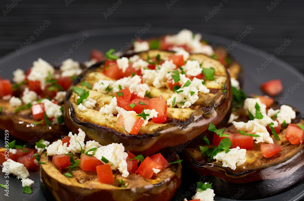 close up homemade eggplant salad with cheese and tomatoes, on a black table. close up homemade eggplant salad with cheese and tomatoes, on a black table.