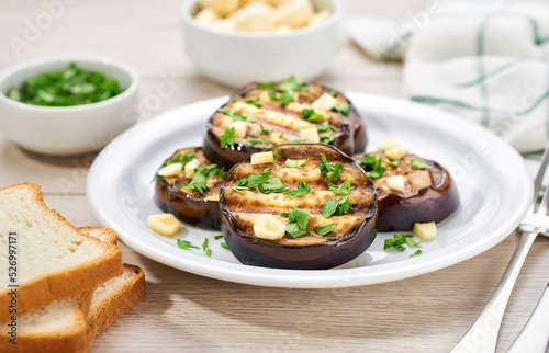 homemade eggplant salad with parsley and garlic on a white table.