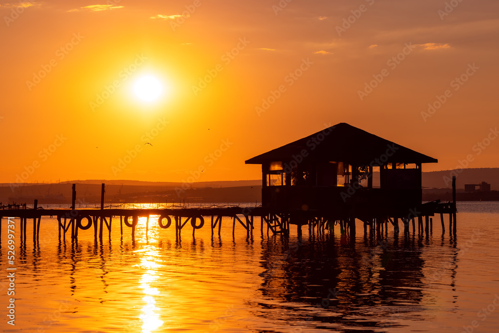 Sunset over the sea lake and old wooden pier, romantic travel destination, nature landscape Sunset over the sea lake and old wooden pier, romantic travel destination, nature landscape