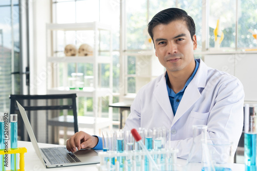 Handsome scientist man with test tube at laboratory