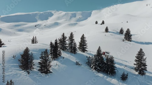 Aerial view of Snowcat ratrack with snowplow transport freestyle skiers, snowboarders on high altitude mountain summit on a sunny winter day. Driving through the deep snow piste in the ski resort photo