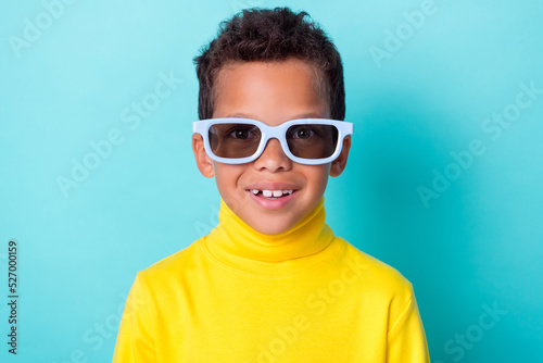 Close up photo of nice positive boy toothy smile dressed yellow stylish outfit spectacles isolated on cyan color background © deagreez