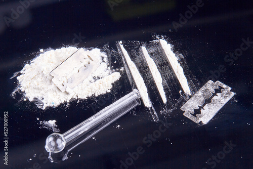 White powder drugs with razor and smoking pipe. Drug use concept. photo