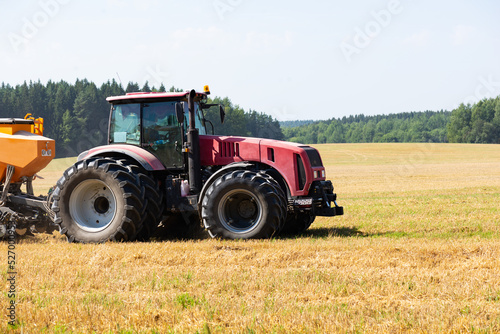 Tractor on the field harvests.