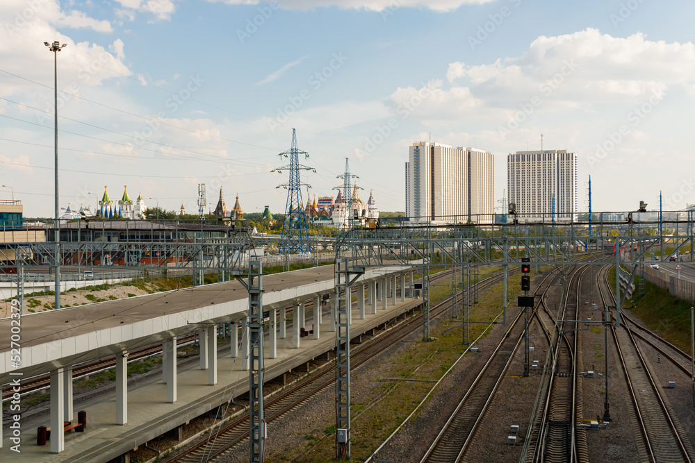 Rails and platform of the Vostochny railway station in Moscow. Izmailovsky Kremlin and hotels in the background.