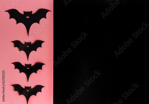 Four silhouettes of bats on a pink background. Creative halloween concept backdrop. halloween bats craft. Black background for text