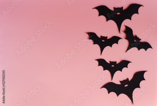 five silhouettes of bats on a pink background. Creative halloween concept backdrop. halloween bats craft.
