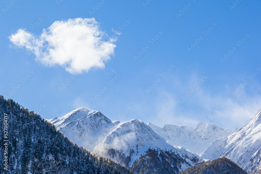 Snow capped mountain peaks with a blue sunny sky