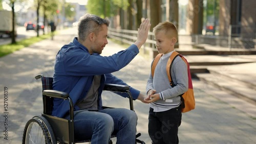 Disabled father tells his son a story and takes five with his son and son goes to school. Education time. amily and disabled people concept photo