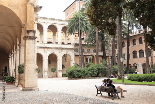 Valokuva Palazzo Venezia Garden View with Archway, Palm Trees and Young People Sitting on
