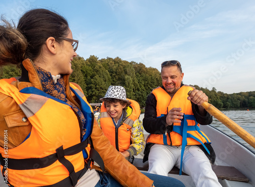 Friendly caucasian family floating on kayak with paddles. Concept of family rest, leisure and weekend at nature. father and daughter wearing life vests. autumn sunny day.Selective focus © kravik93