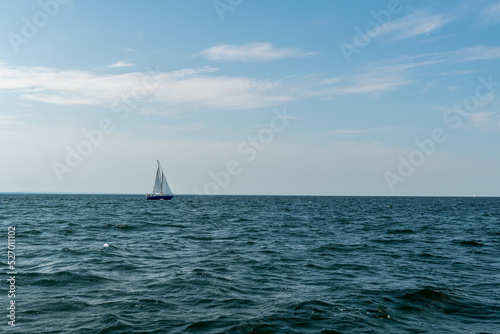 mały jacht żaglowy na spokojnych wodach Morza Bałtyckiego