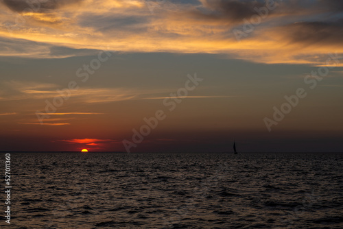 samotny jacht na tle zachodzącego słońca © Kamil_k2p
