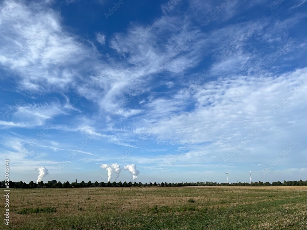 Abgeerntetes Getreidefeld im Spätsommer mit RWE-Türmen im Hintergrund