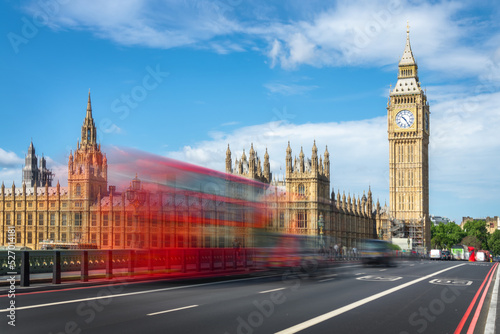 Red double decker bus with motion blur on Westminster bridge  Big Ben in the background  in London  UK