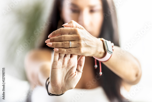 Detail of hands of a woman who stretchesthe wrist in front of her