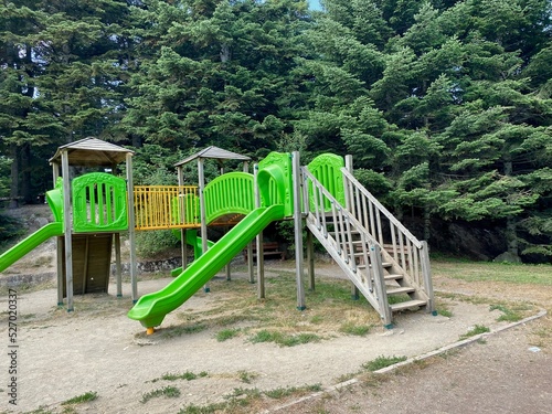 Playground for kids. Children playground in forest with trees built with wood and plastic.