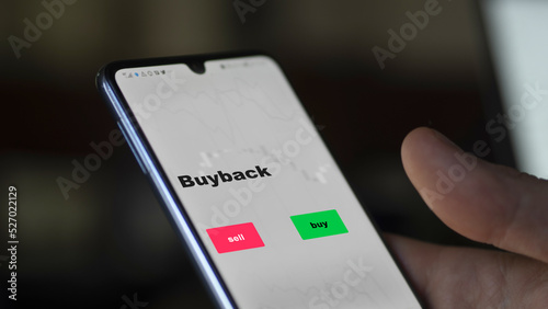 An investor's analyzing the buyback etf fund on screen. A phone shows the ETF's prices epurchases stocks shares to invest