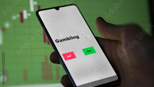 An investor's analyzing the gambling etf fund on screen. A phone shows the ETF's prices casino to invest
