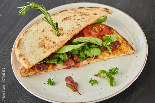 Pita bread filled with meat, vegetables and herbs. Breakfast or lunch. A dish from the chef for serving in a restaurant.