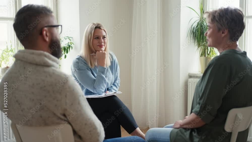 Therapist with people communicating while sitting in circle and talking, group therapy.