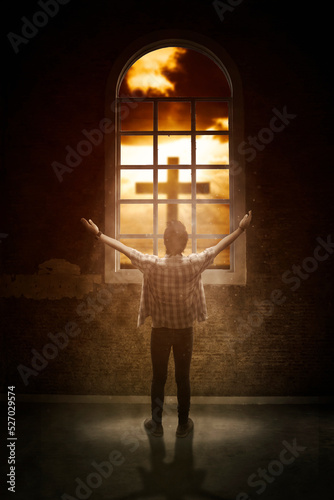 Fotografie, Obraz Man raising hands near window with cross symbol