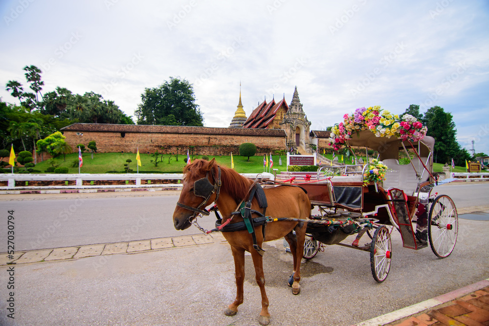 Ancient horse carriage waiting for tourists at Wat Phra That Lampang Luang, Lampang Province, Lampang, Thailand. Ancient horse carriage waiting for tourists at Wat Phra That Lampang Luang, Lampang Province, Lampang, Thailand.